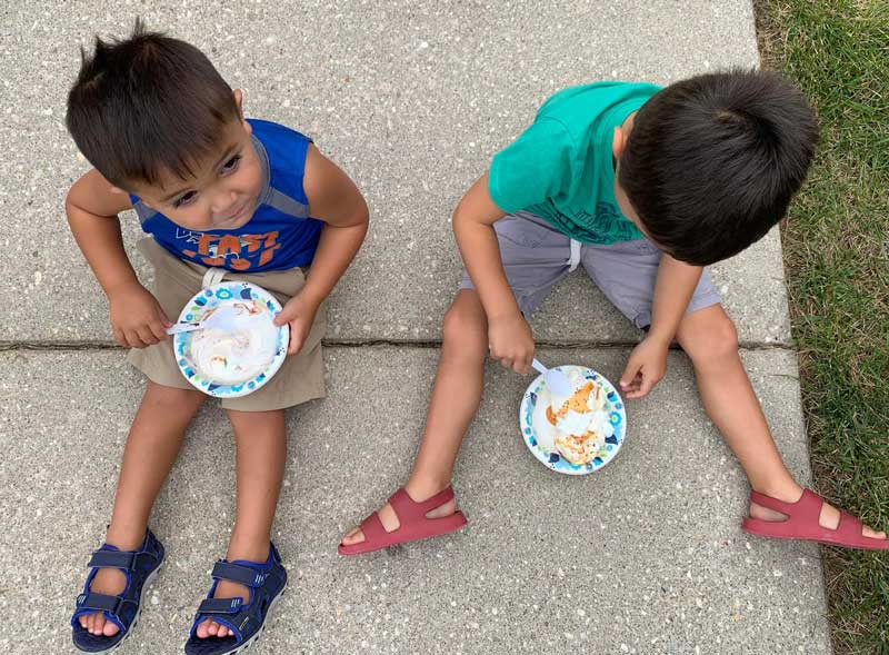 Kids eating ice cream while sitting on the sidewalk at Spencerville Church in Silver Spring, Maryland