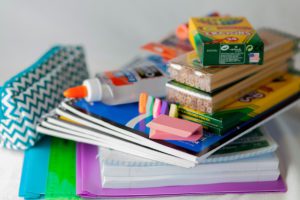 school supplies - glue, crayons, notebooks, paper, markers, pencils