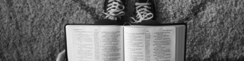 teenager reading the bible in black and white