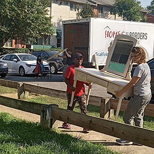 two ladies unloading furniture from a truck