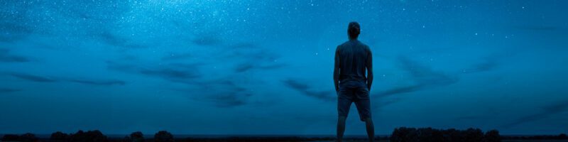 a man staring at the stars in the night sky