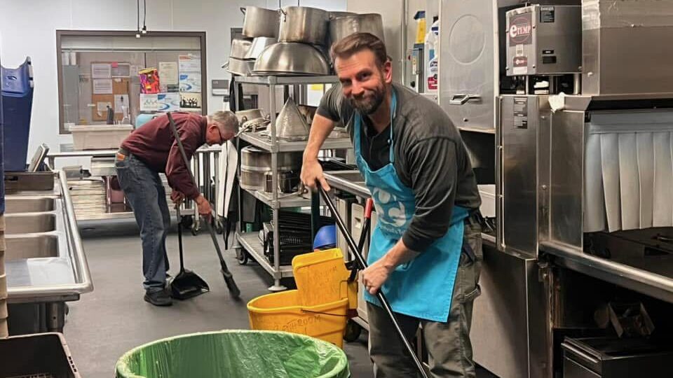man cleaning a commercial kitchen