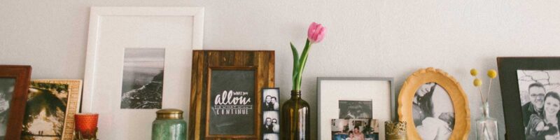 Photos and a vase with flowers on a mantle