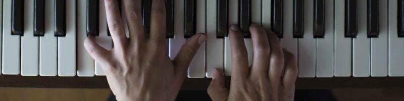 two hands playing the piano