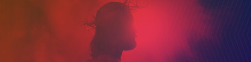 Jesus with a crown of thorns backlit on a purple background